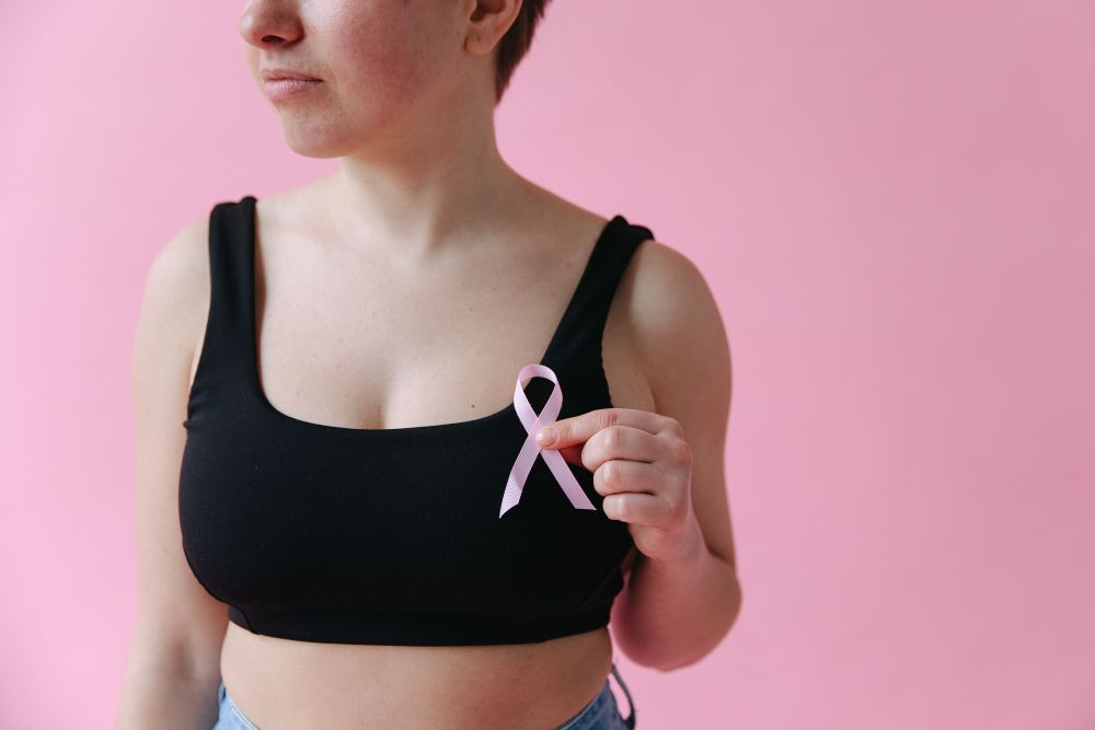 Donna tiene in mano il fiocco rosa simbolo della sensibilizzazione contro il tumore al seno
